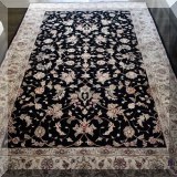 D03. Black and cream colored rug. Approx 5'8” x 8'6” 